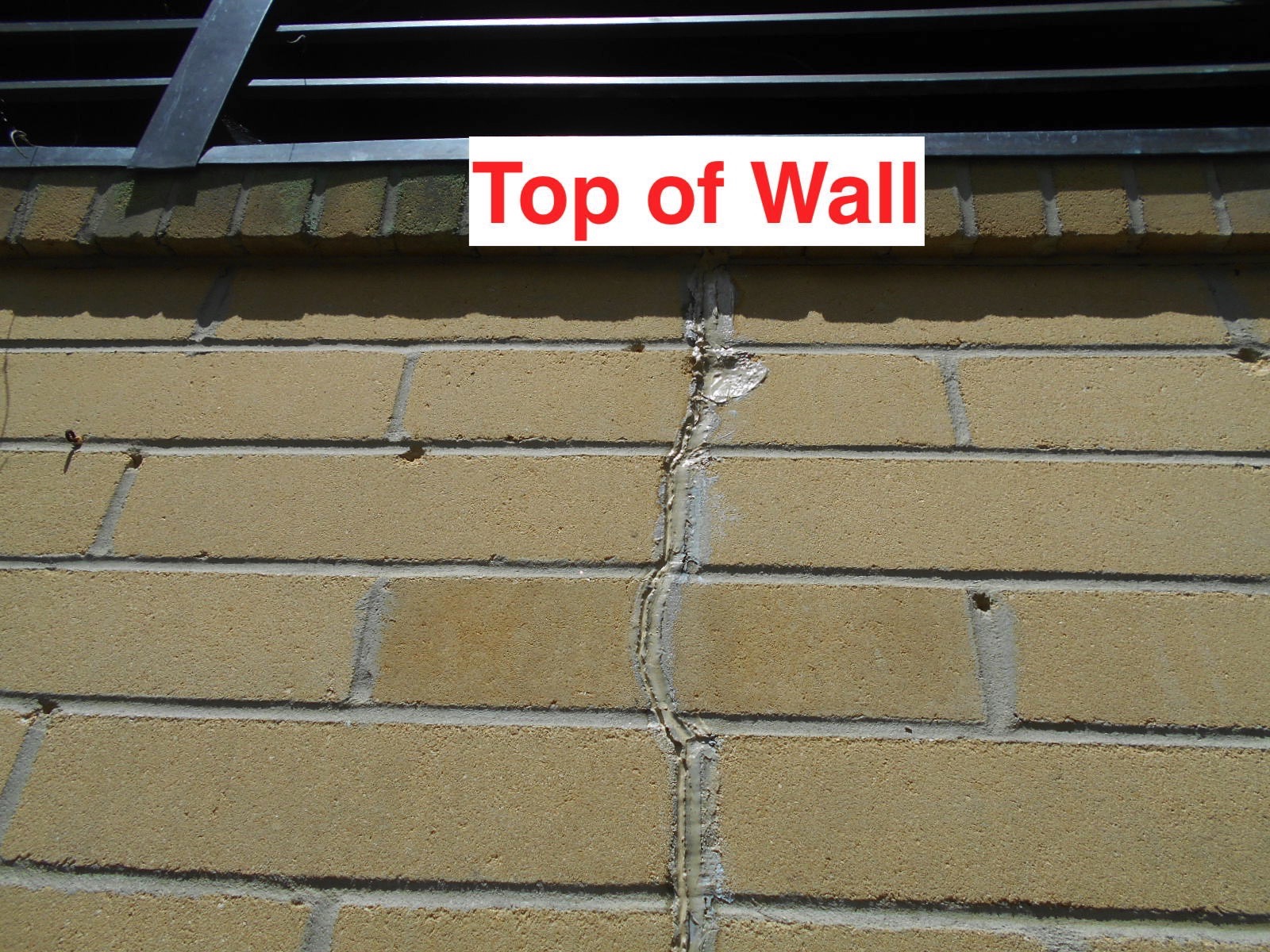 ¿Qué causa una grieta vertical en un bloque de hormigón exterior o en una pared de ladrillo?